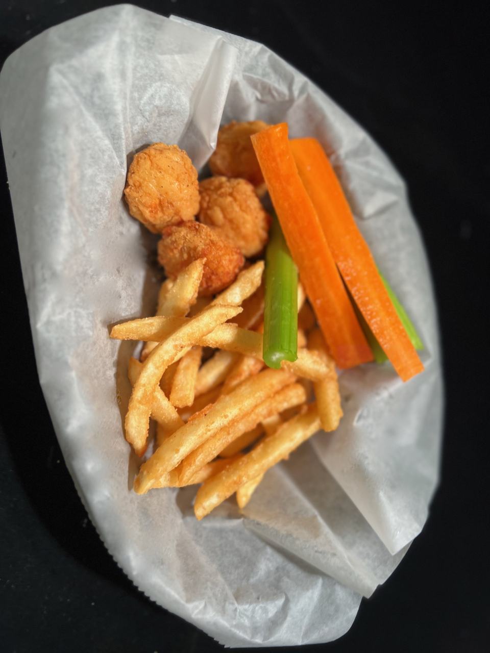 Kids' boneless chicken basket with fries, carrot sticks and celery.