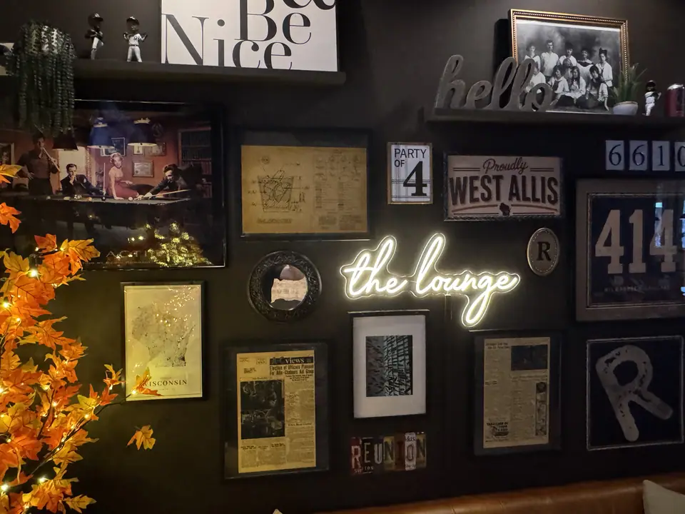 A wall of West Allis and Reunion memorabilia around the glowing lounge sign.