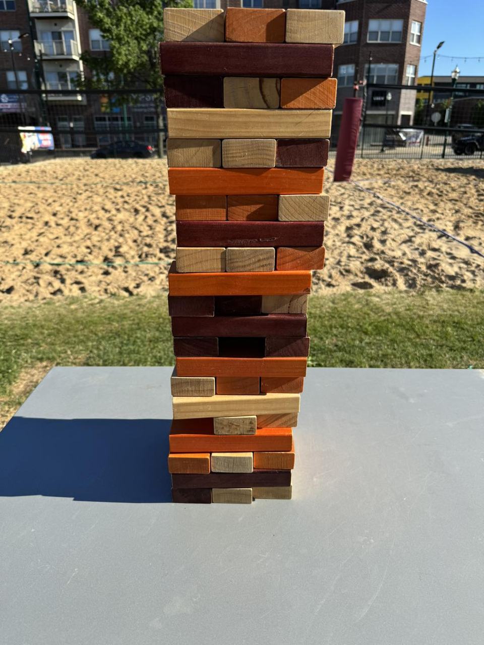 A tall giant Jenga tower on a table at the sand court.